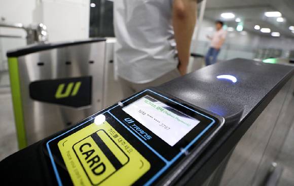 6일 서울 강북구 우이신설선 삼양사거리역에 설치된 티머니 태그리스(Tagless) 게이트에서 업체 관계자가 스마트폰 앱 설정 후 교통카드나 스마트폰 태그 없이 개찰구를 통과하고 있다. [사진=뉴시스]