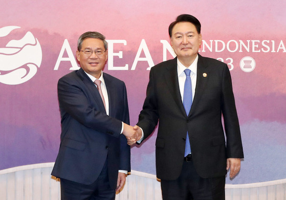 Korean President Yoon Suk Yeol, right, shakes hands with Chinese Premier Li Qiang ahead of a bilateral meeting at the Balai Sidang Jakarta Convention Center Thursday on the sidelines of the Asean gathering in Indonesia. [JOINT PRESS CORPS]