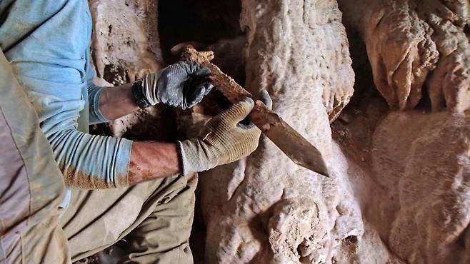 사해 인근 이스라엘 사막 동굴에서 로마 시대 검을 발굴하는 모습.  [이스라엘 문화재청 제공. 재판매 및 DB 금지]