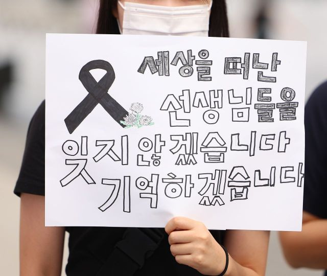 서울 서초구 초등학교에서 숨진 교사의 49재이자 이를 추모하는 '공교육 멈춤의 날'인 지난 4일 오전 서울 광화문광장 이순신 장군 동상 앞에서 열린 '공교육 멈춤의 날' 지지 기자회견에서 참가자가 피켓을 들고 있다. [이미지출처=연합뉴스]