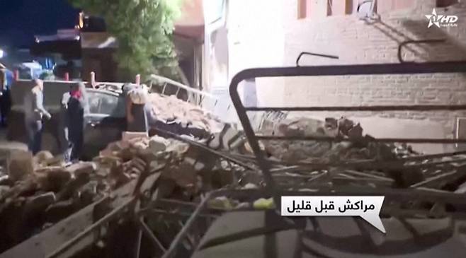 9일(현지시간) 모로코 마라케시에서 주민들이 지진으로 쓰러진 건물 잔해를 살펴보고 있다. 알 아울라 TV 캡처