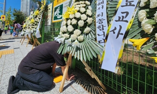 대전 유성구의 한 초등학교 교사가 극단적인 선택으로 숨졌다. 8일 오후 한 동료 교사가 숨진 교사가 근무했던 학교 앞에 놓인 추모 화환 앞에서 오열하고 있다. 연합뉴스