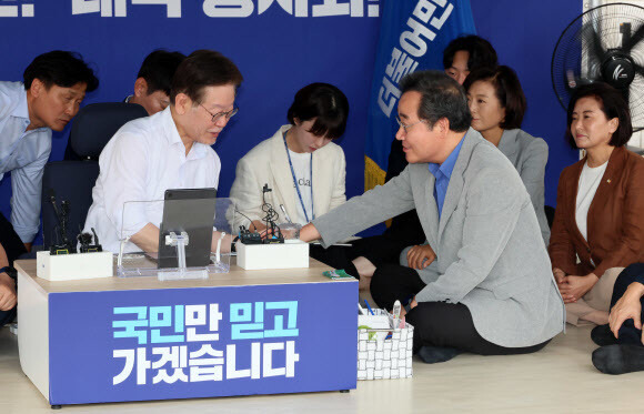 이낙연 전 더불어민주당 대표가 10일 국회 본청 앞 이재명 민주당 대표 단식 농성 천막을 찾아 이 대표의 손을 잡고 있다. 연합뉴스