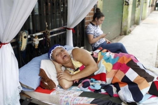 콜롬비아 이타구이 주민 한 사람이 ‘게으름의 날’을 맞아 길거리에 침대까지 펼쳐놓고 잠옷을 입은 채 누워 있다. 사진=에페