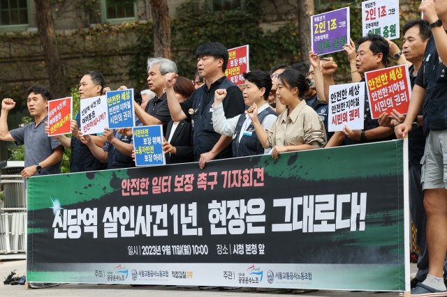 민주노총 공공운수노조, 서울교통공사노조, 직장갑질119 관계자들이 11일 오전 서울시청 앞에서 열린 '신당역 스토킹 살인사건' 1주기 모니터링 보고서 발표 기자회견에서 구호를 외치고 있다. 연합뉴스