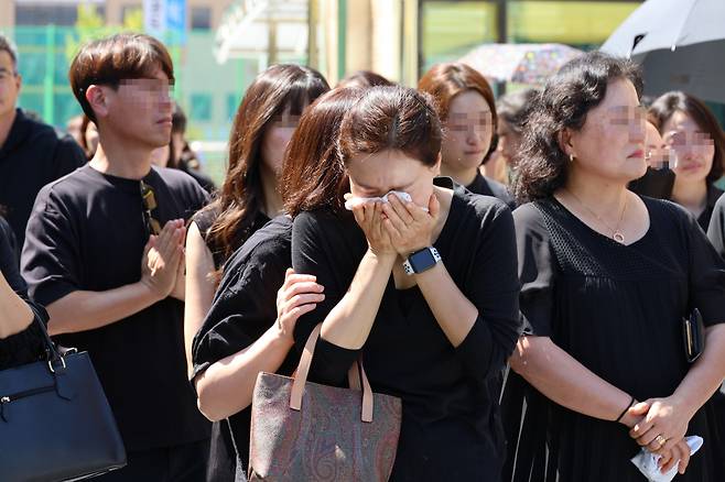 악성민원으로 세상을 뜬 대전 초등 교사의 운구 차량이 9일 오전 교사가 재직하던 유성구 한 초등학교를 떠나자 학부모가 울고 있다. [연합뉴스]