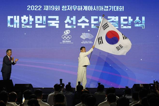 12일 서울 송파구 올림픽공원 올림픽홀에서 열린 2022 항저우 아시안게임 대한민국 선수단 결단식에서 최윤 선수단장이 태극기를 흔들고 있다. 사진 | 방이동=연합뉴스