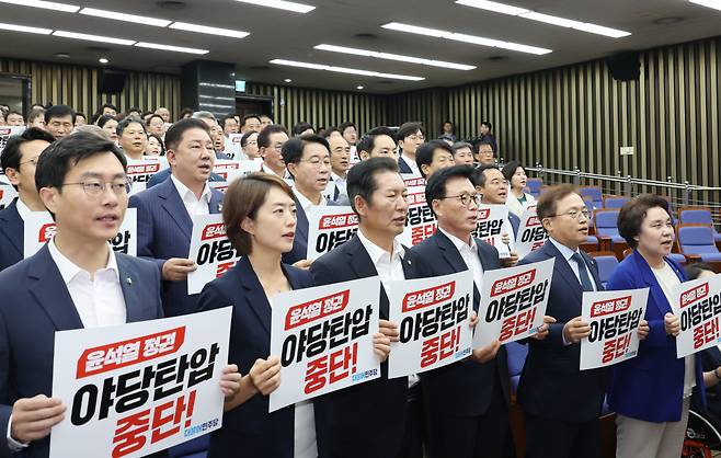 박광온 더불어민주당 원내대표 등이 12일 국회에서 열린 의원총회에서 구호를 외치고 있다. [연합]