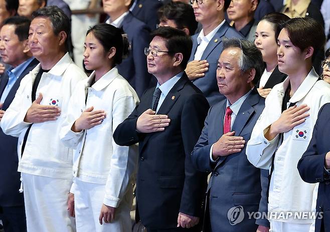 국민의례하는 선수 대표와 관계자들 (서울=연합뉴스) 이지은 기자 = 12일 서울 송파구 올림픽공원 올림픽홀에서 열린 항저우 아시안게임 선수단 결단식에서 선수단과 관계자들이 국기에 대한 경례를 하고 있다. 왼쪽부터 최윤 선수단장, 배드민턴 안세영, 박보균 문화체육관광부 장관, 이기흥 대한체육회장, 수영 김우민. 2023.9.12 jieunlee@yna.co.kr