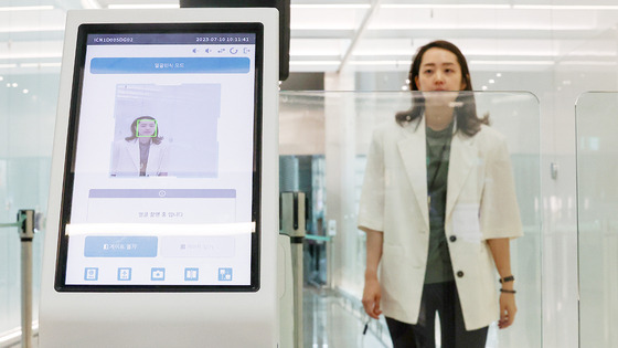 An Incheon International Airport employee demonstrates the Smart Pass service on July 10. The Smart Pass service allows passengers to enter the boarding gate by scanning their faces. [YONHAP]