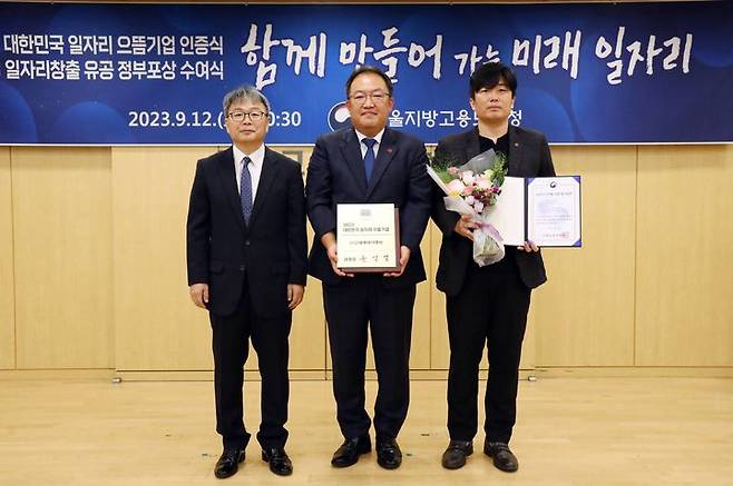 신세계아이앤씨가 고용노동부가 주관하는 ‘대한민국 일자리 으뜸기업’에 3년 연속 선정됐다. 지난 12일 서울지방고용노동청에서 진행된 ‘2023년 대한민국 일자리 으뜸기업 인증식’에서 한훈민 신세계아이앤씨 인사담당 상무(가운데)가 노길준 서울지방고용노동청장(왼쪽)에게서 인증서를 받고 기념촬영을 하고 있다(사진=신세계아이앤씨 제공) *재판매 및 DB 금지