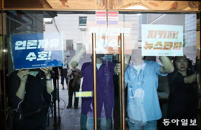14일 오전 서울 중구 뉴스타파 본사 앞에서 직원들이 ‘언론자유 수호’, ‘지키자 뉴스타파’ 등이 적힌 손팻말을 건물 입구에 붙이며 외부인의 출입을 막고 있다. 박형기 기자 oneshot@donga.com