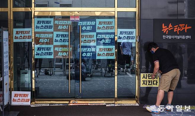 14일 오전 서울 중구 뉴스타파 본사 앞에서 직원들이 ‘언론자유 수호’, ‘지키자 뉴스타파’ 등이 적힌 손팻말을 건물 입구에 붙이며 외부인의 출입을 막고 있다. 박형기 기자 oneshot@donga.com