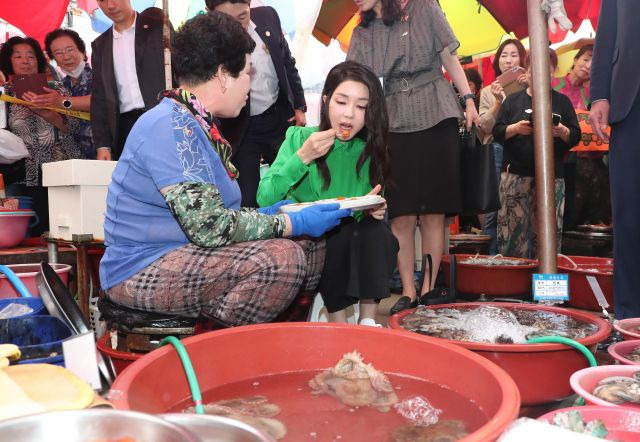 윤석열 대통령 부인 김건희 여사가 14일 부산 기장시장을 찾아 성게를 맛보고 있다. 연합뉴스