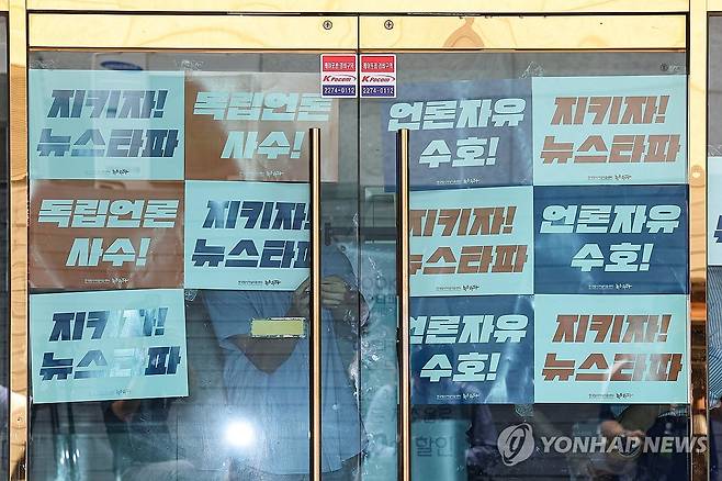 대장동 허위 보도 의혹으로 압수수색 중인 뉴스타파 (서울=연합뉴스) 서대연 기자 = 뉴스타파 직원들이 14일 오전 대장동 허위 보도 의혹으로 압수수색 중인 서울 중구 뉴스타파 출입문 앞에 팻말을 붙이고 있다. 2023.9.14 dwise@yna.co.kr