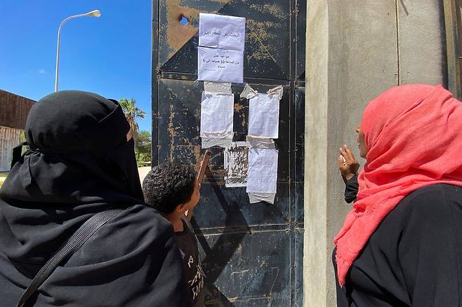 데르나에서 홍수가 발생한 후 실종 공고문을 살펴보는 사람들