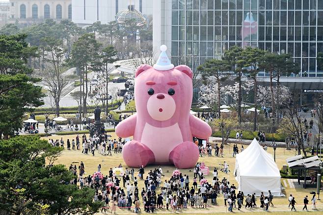 서울 송파구 잠실 롯데월드타워 야외광장에서 열린 초대형 공공전시 ‘어메이징 벨리곰’에 방문한 관람객들이 전시장 곳곳에 비치된 높이 2m의 벨리곰 조형물과 함께 기념촬영을 하고 있다. [연합]