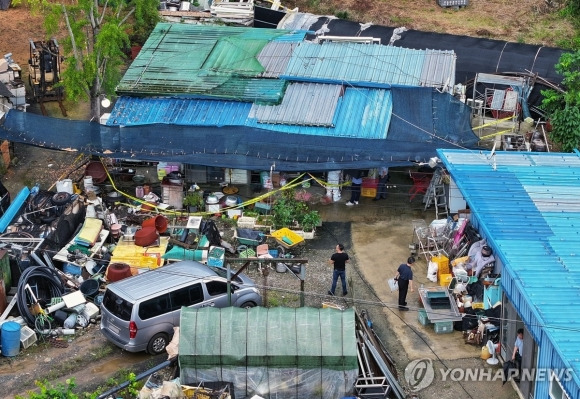 경찰이 일가족 5명이 숨진 농가 내부를 살피고 있다.