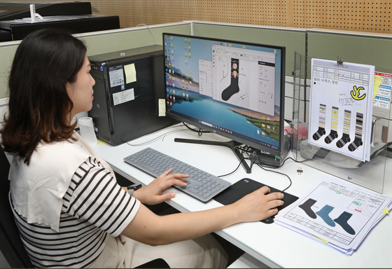An employee at the Seoul Socks Manufacturing Support Center in Dobong District, northern Seoul, on Thursday looks at sample requests. [PARK SANG-MOON]