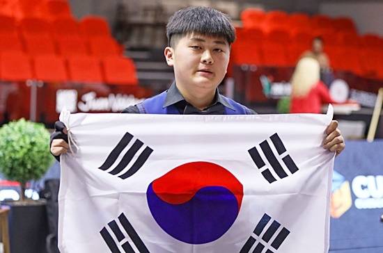 오명규(강원당구연맹)가 제14회 세계주니어3쿠션선수권 결승에서 접전끝에 독일의 이브라모프를 35:33으로 물리치고 우승을 차지했다.  우승을 확정한 후 오명규가 태극기를 들고 포즈를 취하고 있다.  (사진=파이브앤식스)