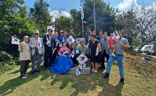 Commemoration ceremony attendants pose next to the Camp Tiano War Memorial in Yanggu-gun, Gangwon Province, Monday. (Courtesy of Jenny Yoon)