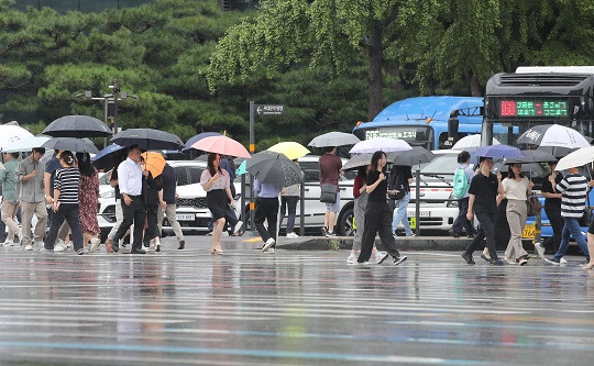 지난 13일 오후 서울 종로구 광화문역 인근에서 시민들이 우산을 쓰고 이동하고 있다. [사진=뉴시스]