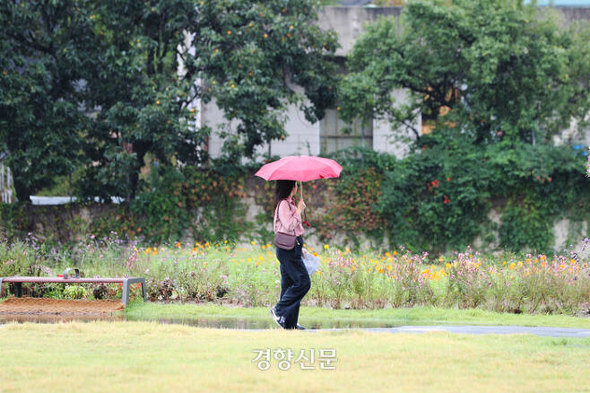 가을비가 내리는 20일 시민이 우산을 쓰고 서울 종로구 열린송현 녹지광장을 산책하고 있다. 한수빈 기자