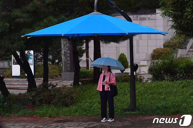 21일 경북 포항시 남구 대이동 교차로에서 우산을 쓴 시민이 대형 그늘막 우산 밑에서 신호를 기다리고 있다.2023.9.21/뉴스1 ⓒ News1 최창호 기자
