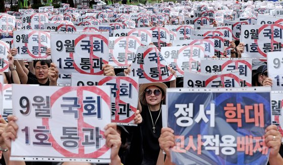 전국 교사들이 16일 오후 서울 여의도 국회의사당 앞에서 열린 '9.16 공교육 회복을 위한 국회 입법 촉구 집회'에서 국회를 향해 교권 회복을 촉구하는 구호를 외치고 있다. 뉴스1