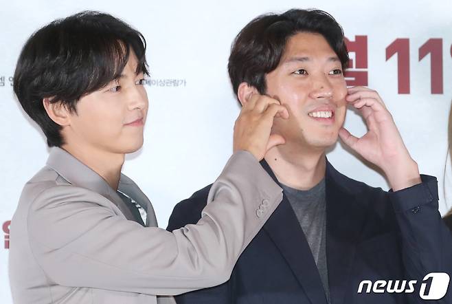 배우 송중기(왼쪽)가 22일 서울 강남구 메가박스 코엑스에서 열린 영화 '화란‘ 언론시사회에서 김창훈 감독의 볼에 하트를 그리고 있다. ⓒ News1 권현진 기자