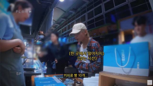 ▲ 그룹 방탄소년단(BTS) 멤버 뷔(본명 김태형)가 강릉에서 게릴라 라이브 이벤트를 진행한 후 강릉의 한 전통시장에서 커피콩빵을 사고 있는 모습.  방탄소년단 공식 유튜브 영상 갈무리