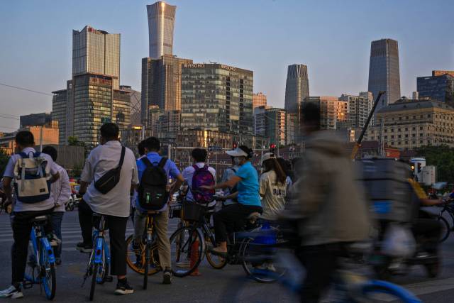 지난 21일 베이징의 출근 시간대에 사람들이 중심업무지구 근처의 교차로를 건너기 위해 기다리고 있다. AP연합뉴스