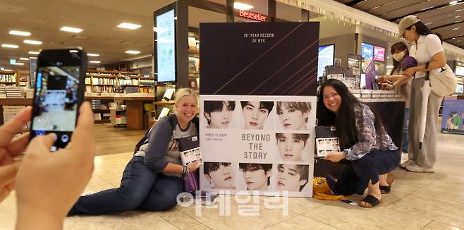지난 7월 서울 종로구 교보문고 광화문점을 찾은 외국인들이 그룹 방탄소년단(BTS)의 데뷔 10주년을 맞아 멤버들의 인터뷰를 엮은 책  ‘비욘드 더 스토리 : 텐 이어 레코드 오브 BTS’(BEYOND THE STORY: 10-YEAR RECORD OF BTS)‘를 구매하고 있다(사진은 기사 내용과 관계 없음). (사진=방인권 기자)