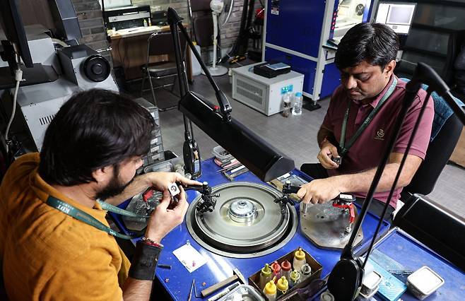 다이아몬드 연마사가 랩그론 다이아몬드의 면을 다듬고 있다.