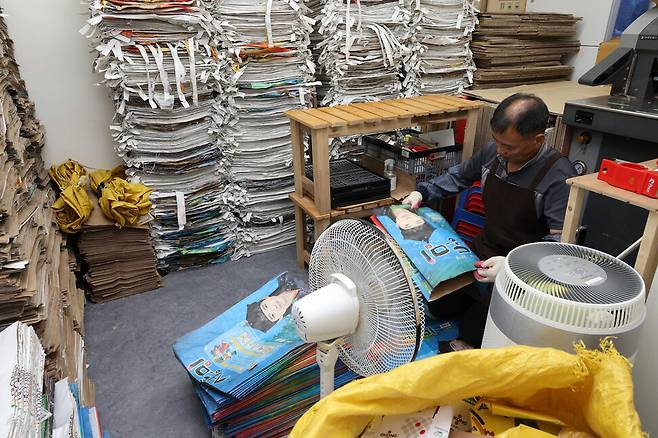 러블리페이퍼 직원이 종이가죽 재료로 쓰이는 쌀포대를 손질하고 있다.