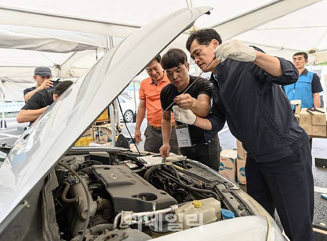 이기재(오른쪽) 양천구청장이 17일 양천구청 주차장에서 진행된 추석맞이 구민대상 자동차 무상점검 현장에서 정비 상황을 점검하고 있다. (사진=이데일리 김태형 기자·양천구)