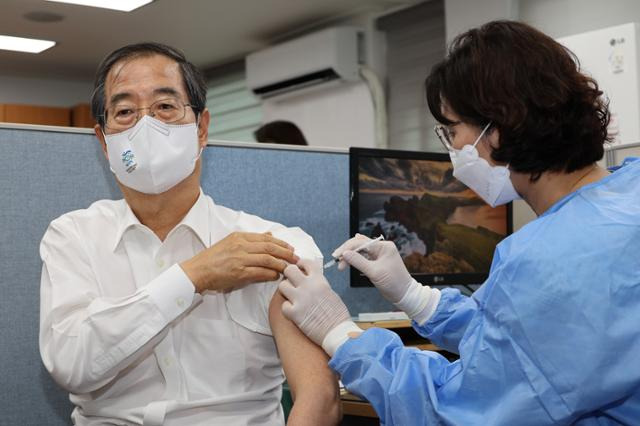 한덕수 국무총리가 지난해 7월 8일 서울 종로구보건소에서 코로나19 4차 예방접종을 하고 있다. 연합뉴스