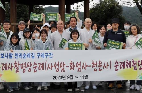 명상순례길 체험단과 기념사진 찍는 꽃스님 (구례=연합뉴스) 이세원 기자 = 21일 전남 구례군 섬진강 인근 도로에서 '구례사찰명상길' 순례체험단과 이 행사에 명사로 초청된 '꽃스님' 범정스님(오른쪽 첫번째 승려)이 기념 사진 촬영에 응하고 있다.