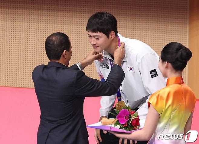 오상욱이 25일 오후 중국 항저우 디안즈대학 체육관에서 열린 2022 항저우 아시안게임 펜싱 남자 사이 브르 개인전 메달 수여식에서 금메달을 목에 걸고 있다. 2023.9.25/뉴스1 ⓒ News1 신웅수 기자