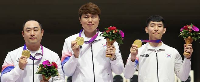 북한 넘고…사격 남자 10m 러닝타깃 단체전 ‘금’ 한국 남자 사격 대표팀 하광철, 정유진, 곽용빈(왼쪽부터)이 25일 항저우아시안게임 사격 남자 10m 러닝타깃 단체전 금메달을 목에 걸고 미소짓고 있다. 한국은 2위 북한(1668점)과 총점은 같았지만, 이너텐(Inner Ten·10점 정중앙) 횟수에서 39회-29회로 앞서 금메달을 따냈다. 항저우 | 연합뉴스