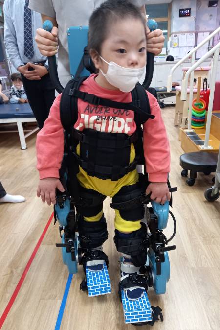 현우가 지난 4월 부산 큰솔병원에서 로봇 치료기기를 활용해 걷는 연습을 하며 물리치료를 받고 있다. 해당 물리치료는 비급여로 전환돼 현우의 치료가 중단됐다. 김정미씨 제공