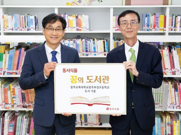 정종문 광주교대 부설초 교장(왼쪽)과 최상인 동서식품 홍보상무가 '제7회 꿈의 도서관' 도서기증식에서 기념촬영을 하고 있다.[사진제공=동서식품]