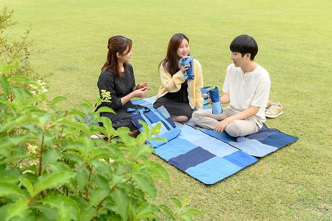 서울 양천구 주민들이 폐청바지로 만든 바닥매트에 앉아 휴식을 취하고 있다. |양천구 제공