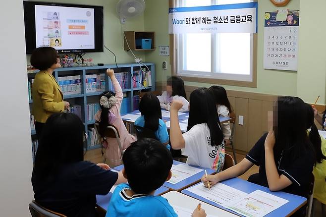 우리금융저축은행 관계자가 지난 22일 충북 청주의 ‘방주지역아동센터’에서 금융교육을 하고 있다. 우리금융저축은행 제공