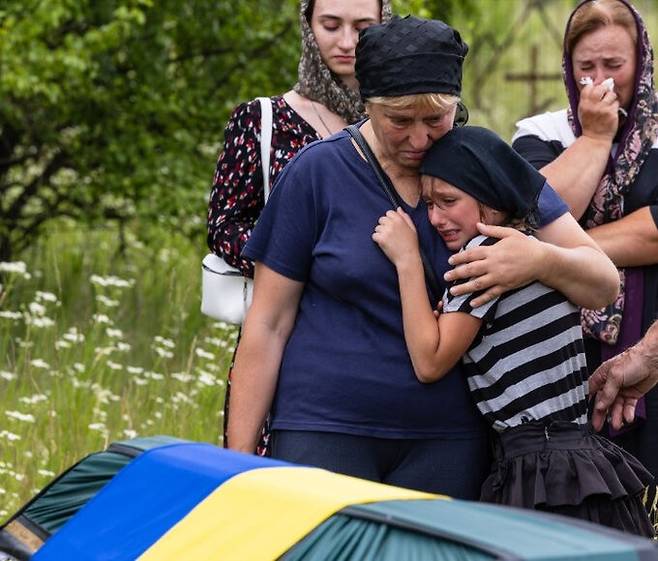 2022년 6월 러시아군에 의해 살해된 우크라이나 남성의 장례식에서 딸이 아버지의 관을 바라보며 오열하고&nbsp;있다. 세계일보 자료사진