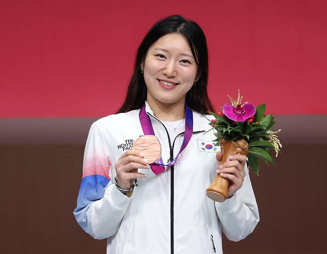 여자 펜싱 홍세나가 25일 중국 항저우 전자대학 체육관에서 열린 여자 플뢰레 개인전에서 동메달을 차지한 후 시상대 위에서 웃고 있다. 연합뉴스