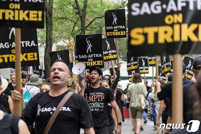 지난 7월19일(현지시간) 미국작가조합(WGA)의 파업에 합류한 미국배우·방송인노동조합(SAG·AFTRA) 조합원들이 미국 뉴욕에서 손팻말을 들고 거리를 행진하고 있다.2023.9.25. ⓒ AFP=뉴스1 ⓒ News1 김기성 기자