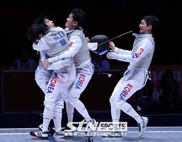 27일(현지시간) 중국 항저우 전자대학 체육관에서 열린 2022 항저우 아시안게임 펜싱 플뢰레 남자 단체전 결승 한국 대 중국의 경기, 중국을 꺾고 금메달을 차지한 뒤 한국 이광현(왼쪽 앞), 허준(왼쪽 뒤), 하태규, 임철우(오른쪽)가 부둥켜 안고 있다. 사진┃뉴시스