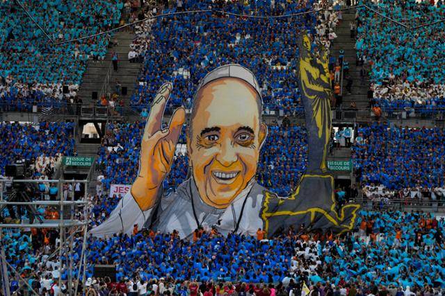 프란치스코 교황이 9월 24일 토요 미사를 위해 프랑스 마르세유의 벨로드롬 경기장에 도착하자, 참가자들이 대형 프란치스코 교황 이미지를 들어 올리고 있다. 지중해 주교 회의 참석차 마르세유를 찾은 프란치스코 교황은 에마뉘엘 마크롱 대통령에게 유럽 국가들이 이주민·난민에 책임감을 느껴야 한다고 강조하면서 항구를 열어줄 것을 촉구했다. 마르세유=AP 뉴시스