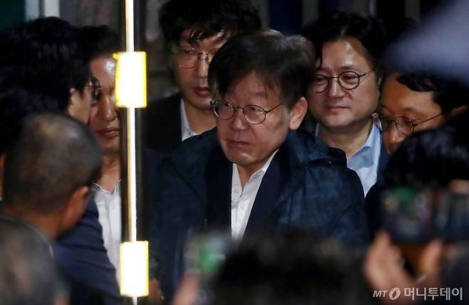 이재명 더불어민주당 대표가 27일 새벽 법원의 구속영장 기각 이후 경기 의왕시 서울구치소를 나서며 당직자들과 인사를 나누고 있다. /뉴시스=공동취재사진